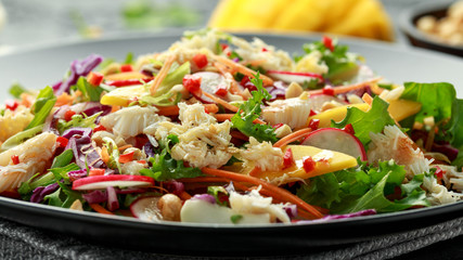 Crab salad with vegetables, radish, carrots, mango, pine nuts and prawn crackers