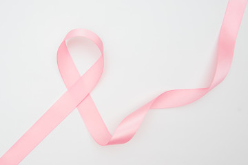 Obraz na płótnie Canvas Curled pink ribbon with highlights isolated on white background, top view