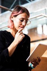Beautiful young Caucasian woman, girl or student with hipster style and eyeglasses thinking and...