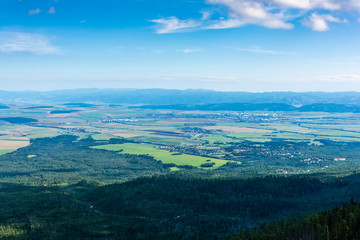 Fototapeta na wymiar View of the lowlands and, among others, the city of Poprad from the Tatra Mountains. On the horizon visible range of the Low Tatras. Slovakia.