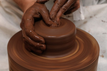 Blurred motion closeup of female or male hands. Work with clay on a pottery wheel. Soft focus. Background on the theme of craft or handmade.