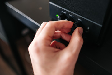 A close-up photo of a male hand that holds out his hand to increase the bass. 