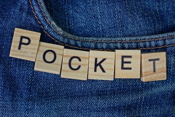 pocket on a blue trouser fabric with the word made of wooden letters