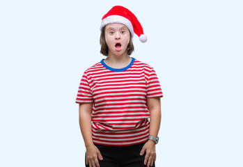 Young adult woman with down syndrome wearing christmas hat over isolated background afraid and shocked with surprise expression, fear and excited face.