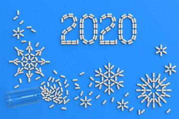 A lot of pills scattered on a blue background in the form of snowflakes and numbers 2020. 3D illustration