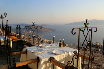 Romantic interior in the top roof restaurant in Saranda in Albania. Panoramic view from Lecursi castle.