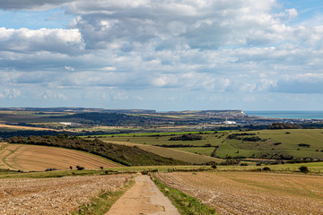 Fototapeta na wymiar Looking along a pathway in the South Downs with Newhaven and the coast in the distance