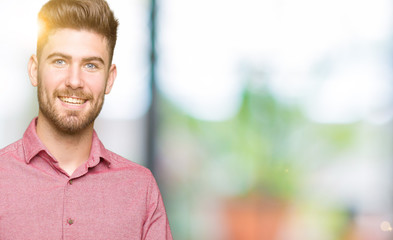 Fototapeta premium Young handsome business casual man smiling cheerful presenting and pointing with palm of hand looking at the camera.