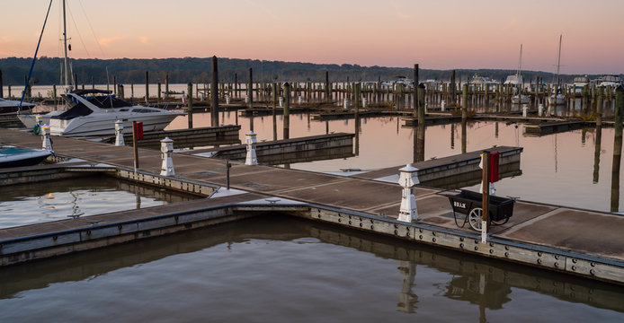 Marina Dock Golden Sunrise with Power Pedestals and Boats on a Still River