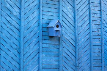 blue birdhouse on a blue wooden wall