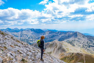 Young woman traveler in the bulgarian mountains , hiking in the sunny day