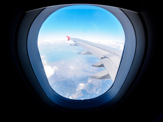 View of the mountains from the airplane porthole. Travel concept