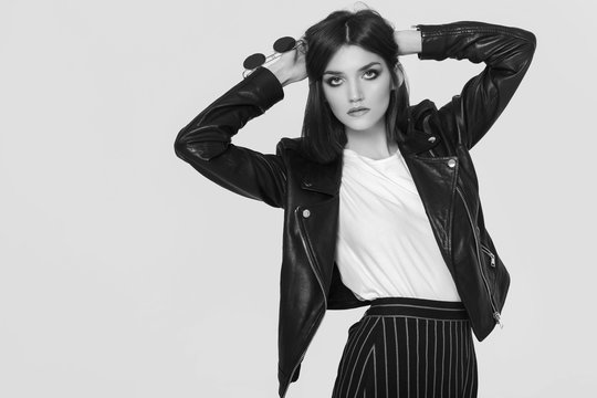 Fashion portrait of a young woman in leather jacket. Black and white image 