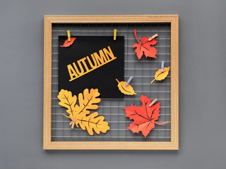 Photo grid board with red and orange paper Autumn leaves and text "Autumn". Fall paper craft concept for interior design or creative ideas for decorating your house.