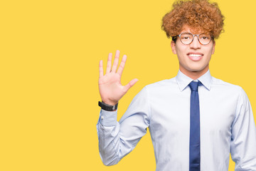 Young handsome business man with afro wearing glasses showing and pointing up with fingers number five while smiling confident and happy.