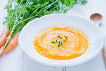 Creamy Carrot Soup on white wooden background