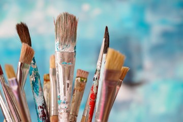 Paint brushes in front of blurred canvas