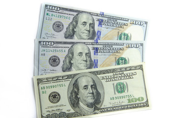 American dollars denominations of one hundred, fifty, five. Arranged in a chaotic manner, a short flight of stairs, a bill on a bill. Old sample and new notes. Dollars in hands are twisted into a tube