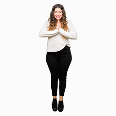 Fototapeta premium Young beautiful woman wearing white sweater praying with hands together asking for forgiveness smiling confident.