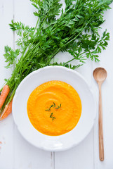 Creamy Carrot Soup on white wooden background