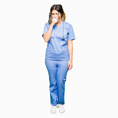 Young adult doctor woman wearing medical uniform feeling unwell and coughing as symptom for cold or bronchitis. Healthcare concept.