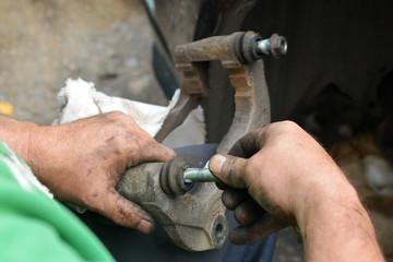 Replacement of worn disc brake system of the car. The mechanic carries out maintenance of brakes. Garage repair of the car.
