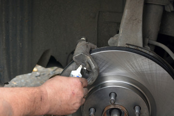 Replacement of worn disc brake system of the car. The mechanic carries out maintenance of brakes. Garage repair of the car.