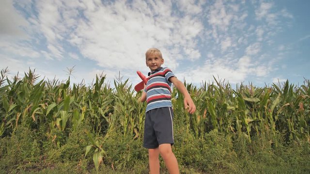 A little boy launches a paralon toy airplane.