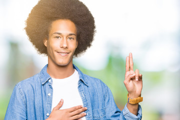 Young african american man with afro hair Swearing with hand on chest and fingers, making a loyalty...