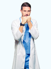 Handsome doctor man wearing medical uniform over isolated background Ready to fight with fist defense gesture, angry and upset face, afraid of problem