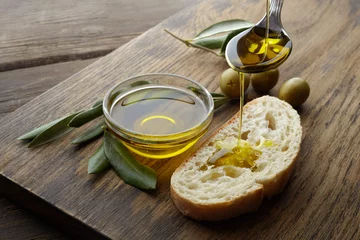 Poster Im Rahmen mit Olivenöl gewürzte Scheibe Brot auf Holzuntergrund © vetre