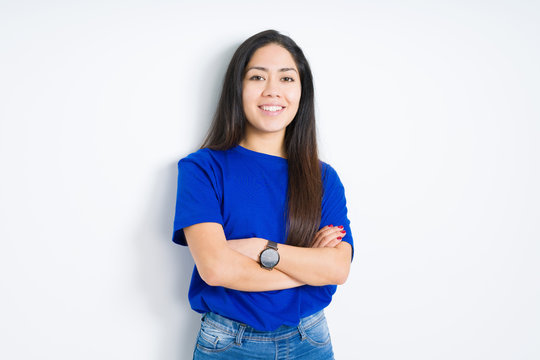 Beautiful young brunette woman standing with crossed arms and smiling over isolated background