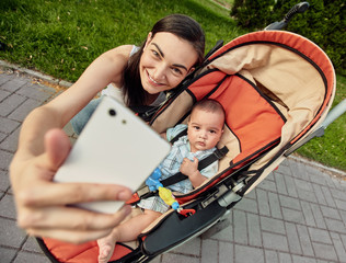 Happy smiling mother making selfie with cute little son