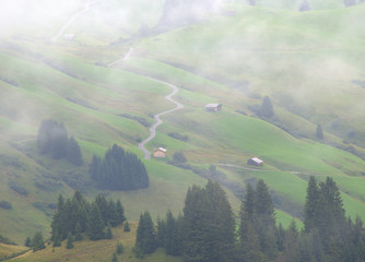 Curvy mountain road crossing the Alps in diagonal with a hiking man in red jacket