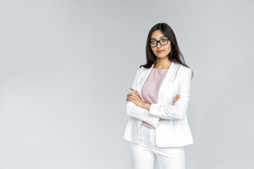 Successful and confident young adult indian business lady teacher standing isolated on grey...
