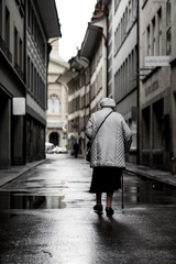 Obraz premium Old woman walks in alley