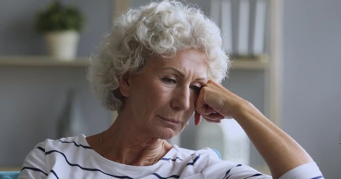 Sad thoughtful mature old adult woman looking away feeling depressed