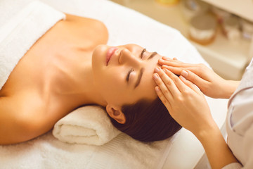 Obraz na płótnie Canvas Facial massage to a beautiful girl in a beauty clinic.