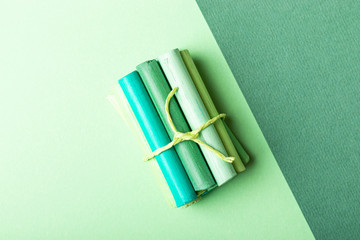 A few pastel crayons tied with a ribbon on green pastel paper. Green palette