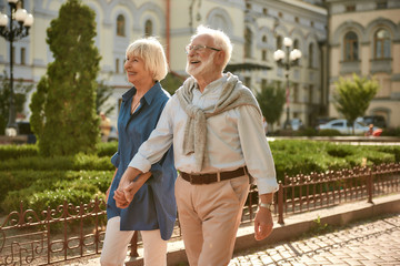 True love has no expiration date. Happy and beautiful elderly couple holding hands while walking outdoors