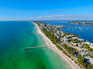 Aerial view of Cortez beach withe sand beach and his little wood pier on blue water, Anna Maria...