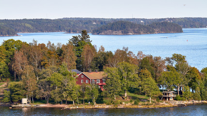 Isla en fiordo con Cabaña de madera rodeada de árboles 