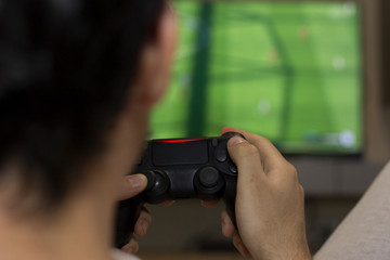 The guy is playing on the console. Back view of concentrated young gamer playing game.  controller video console playing player holding hobby playful enjoyment view concept.
