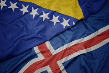 waving colorful flag of iceland and national flag of bosnia and herzegovina.