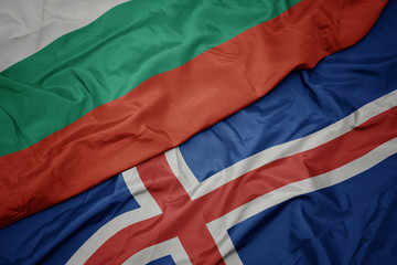 waving colorful flag of iceland and national flag of bulgaria.