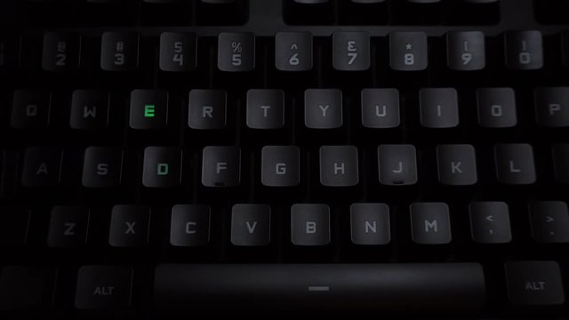 The word weed is typed on a luminous computer keyboard. Black backlit keyboard with letters. The keyboard itself prints the word using the backlight.
