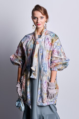 Fashion model in colorful pastel zipper coat and silk dress