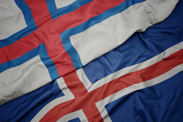 waving colorful flag of iceland and national flag of faroe islands.