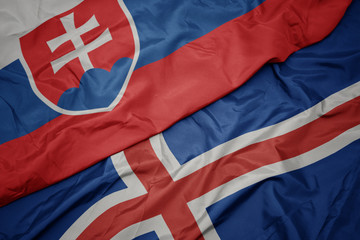 waving colorful flag of iceland and national flag of slovakia.