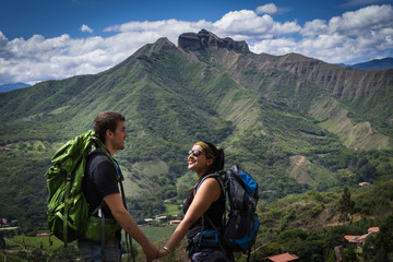 Fototapeta premium Backpacker couple holding hands surrounded by a natural landscape. Vilcabamba, Ecuador